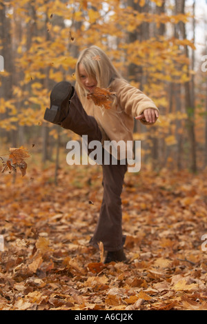 Girl Kicking Leaves Stock Photo