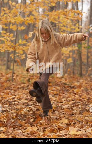 Girl Kicking Leaves Stock Photo