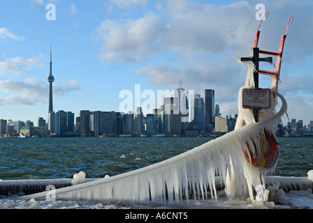 Icicle covered life guard equipment overlooking Lake Ontario in winter with Toronto skyline Stock Photo
