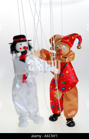 Happy clown puppets on a string presenting each other on stage with white background Stock Photo