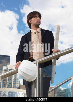 Businessman Holding Hard Hat and Blueprints