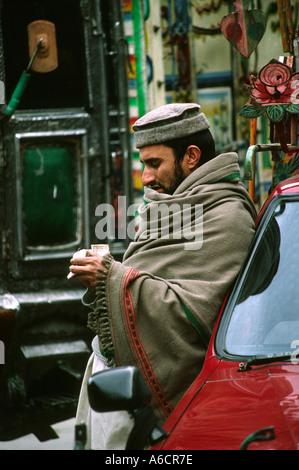 Pakistan Swat Valley Mingora Bazaar man wrapped against the cold counting money Stock Photo