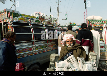 Pakistan Rawalpindi elderly man selling newspapers at bus stand Stock Photo