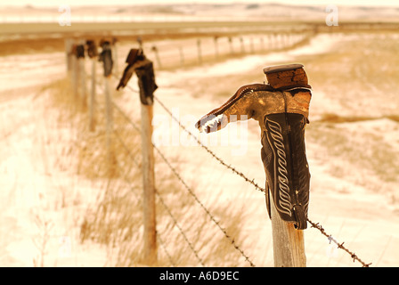 Cowboy boots on a fence Stock Photo