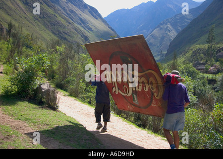 Porters carrying a sign advertising board on the ancient inca path known as the Inca Trail to Machu Picchu Stock Photo