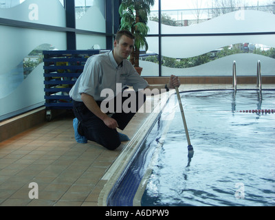 Carrying out routine tests on water quality in an indoor swimming pool. Stock Photo