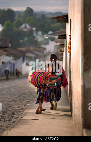 Guatemala Chichicastenango Young Maya girl in traditional village dress walking home Central America Stock Photo