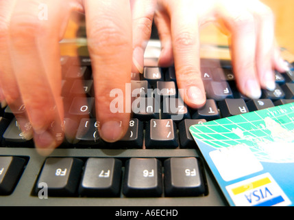 Womans finger typing on the keyboard - Shopping online with Visa credit card Stock Photo