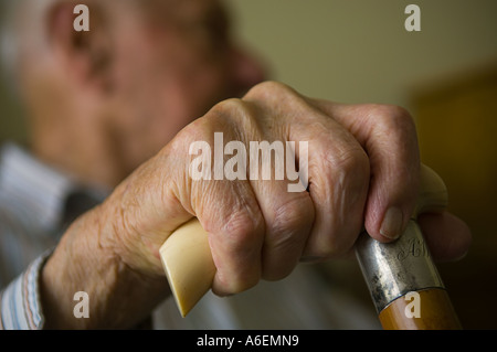 Close up of an elderly mans hand holding an ivory handled walking stick Stock Photo