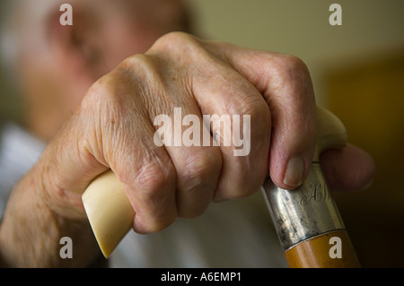 Close up of an elderly mans hand holding an ivory handled walking stick Stock Photo