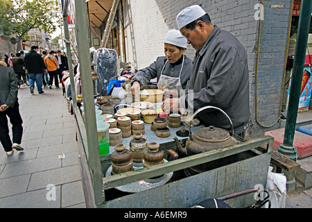 CHINA XIAN Street vendors preparing decorated sweet cakes to sell on cart in the Muslim Quarter of old Xi an Stock Photo