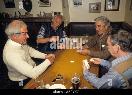 Four men 60s 70s enjoying a domino game in a pub in northern England in the 1980's. Stock Photo