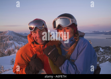 A snowboarding couple stands on the summit of Diamond Peak ski resort NV Stock Photo