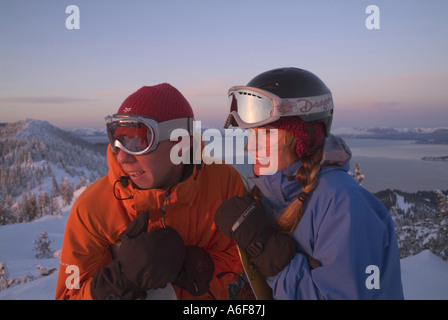 A snowboarding couple stands on the summit of Diamond Peak ski resort NV Stock Photo