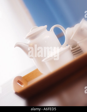 White teapot on tray with sugar bowl and cups Stock Photo