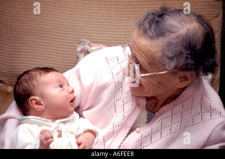 Generation gap close up portrait 5 week old model released new born baby boy & 90 year M/R Great Grandmother pensioner wearing glasses England UK Stock Photo