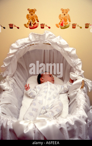 New born baby boy 5 weeks old resting in crib cot nursery bedroom wearing baby grow one piece 1997 archive image stick on wall decorations England UK Stock Photo