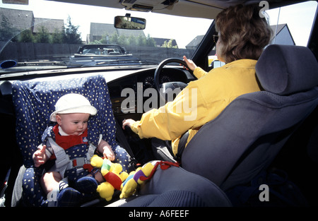 Child car safety seat rear facing as fitted in 1996 historical archive view of newborn baby boy travelling in mothers car along busy road England UK Stock Photo