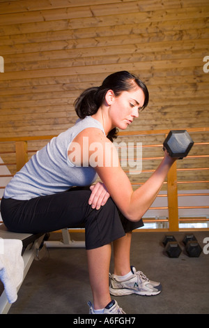 young woman lifting weights in private home gym Stock Photo