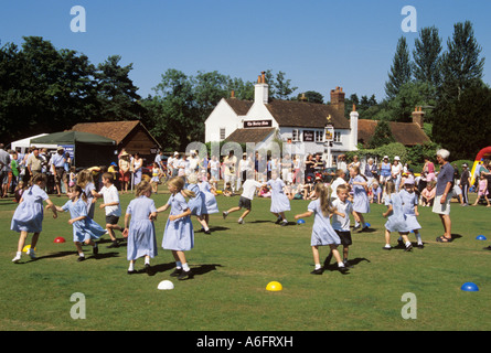 TILFORD VILLAGE SUMMER FETE with children country dancing on a village green. Tilford Surrey England UK Britain Stock Photo