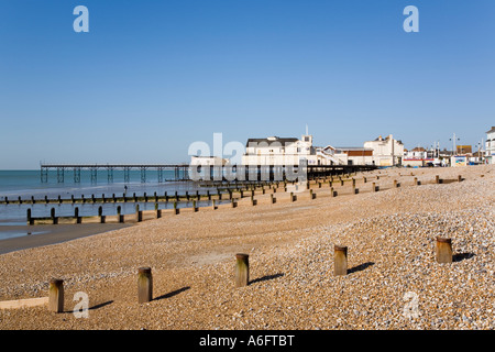 Empty pebble beach sea at low tide wooden breakwater posts and pier out of season. Bognor Regis West Sussex England UK. Stock Photo