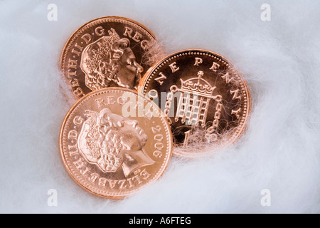 Three UK copper penny coins in close up wrapped in cotton wool for protection Stock Photo