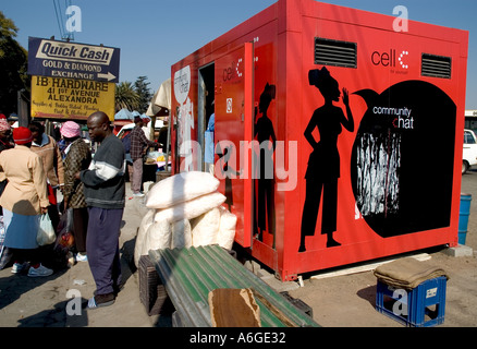 South Africa Johanesburg Alexandra Township red public phone booth plus people in the street Stock Photo