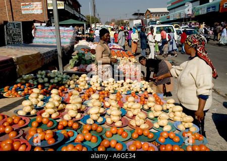 South Africa Johanesburg Alexandra Township vegetable stall on the street with people in bkgd Stock Photo