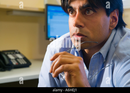 east indian male executive in office cubicle Stock Photo