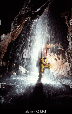 Caver with a waterfall in Piccadilly Ogof Ffynnon Ddu Brecon Beacons South Wales Stock Photo