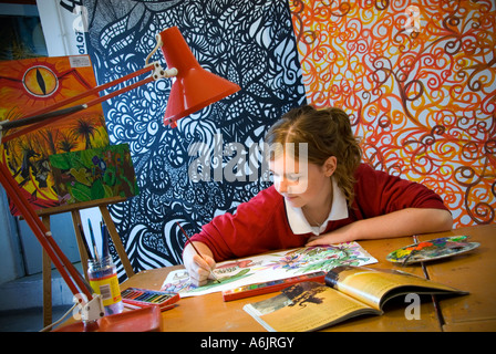 Teenage girl student in uniform working on her oil painting project in school art classroom Stock Photo