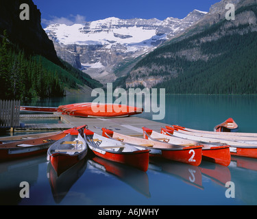 Banff National Park Canada: Red canoes on Lake Louise with Mount Victoria and Victoria Glacier in the distance Stock Photo