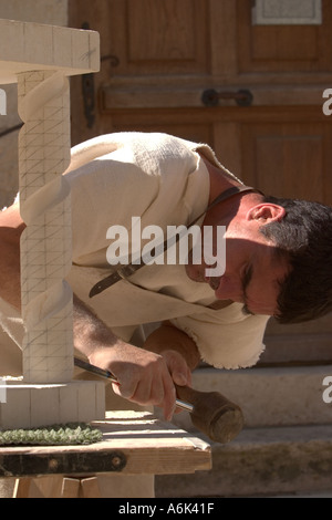 French Stonemason, man in french period costume carving stone spiral at french medieval festival in Monflanquin Aquitaine South West France europe eu Stock Photo