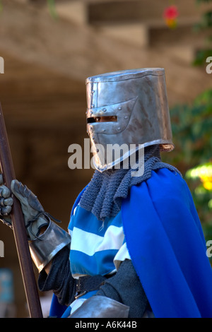 Medieval  knight wearing blue robes and steel helmet holding lance in close up at medieval festival in Monflanquin Aquitaine South West France eu Stock Photo