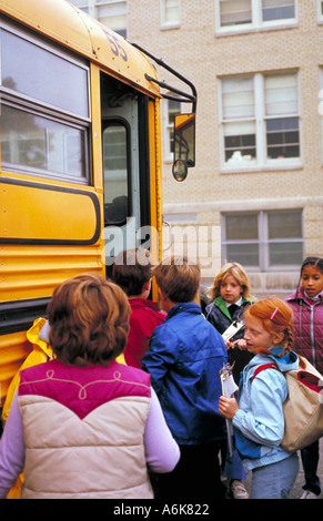 Children getting on school bus Stock Photo