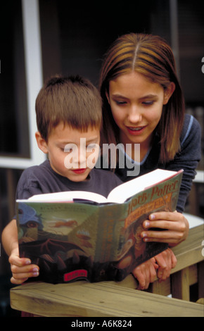 Big Sister reading to Little Brother Stock Photo
