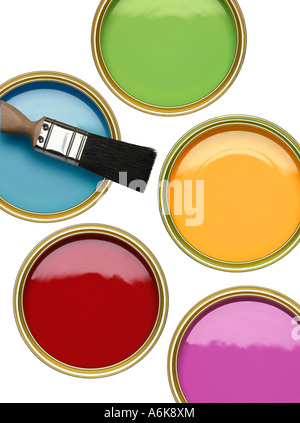 TINS OF BLUE GREEN RED YELLOW AND PURPLE PAINT WITH BRUSH ON WHITE BACKGROUND Stock Photo