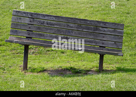 park bench with one side pushed into the grass to show effects of obesity Stock Photo