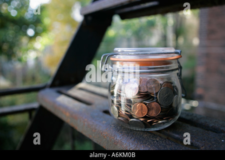 Jar filled with coins on fire steps close up Stock Photo