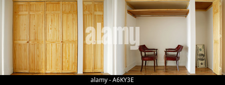 Two old armchairs inside cabinet Huge size 100 dollar bill lean against wall inside wardrobe Stock Photo