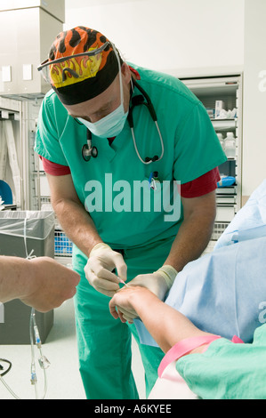 Anesthesiologist does blood work on patient during surgery Stock Photo