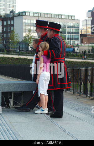 Tower Hill unknown visiting youngsters posing for photographs with 2 two yeoman warders outside the Tower of London Stock Photo