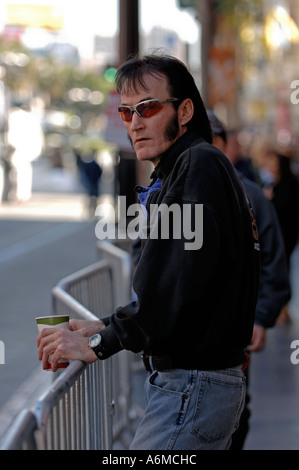 Elvis Presley impersonator walking along Hollywood Walk of Fame smoking a  cigarette and holding a cup of coffee Stock Photo