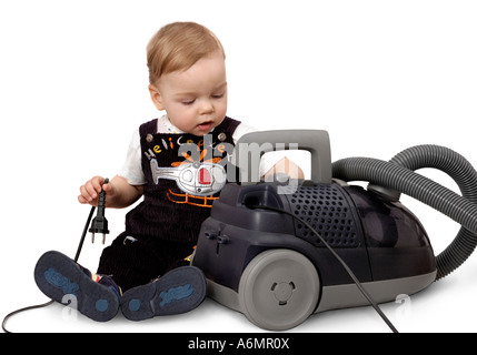 Cute baby boy playing with a vacuum cleaner Stock Photo