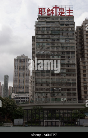 Neglected apartment block overlooking a city centre football pitch in Causeway Bay Stock Photo