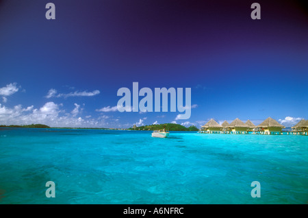 Shades of turquoise waters , thatched bungalows and water taxi , Bora Bora Stock Photo