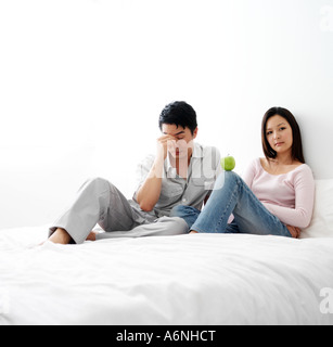 Couple sitting in bed, having troubles Stock Photo