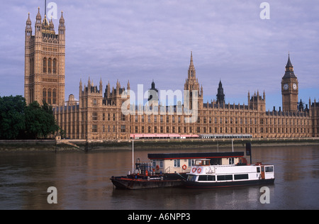 Tour boat and refuelling barge on River Thames before Houses of Parliament, London, England Stock Photo