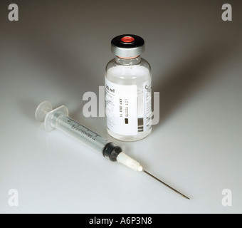 Hypodermic syringe alongside dispensary bottle of an injectable drug Stock Photo