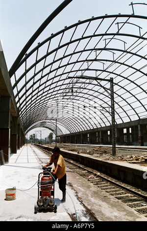 ASB77406 Indian worker polishing marble tiles during the construction of Kharghar Railway station, New Bombay, India Stock Photo